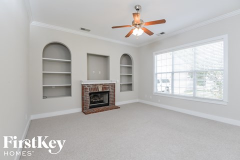 a living room with a fireplace and a ceiling fan