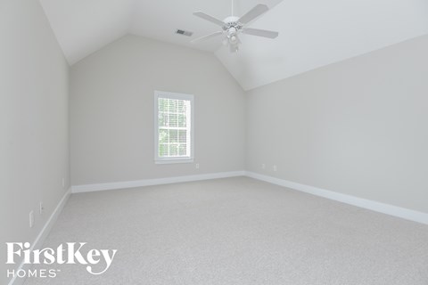 a bedroom with white walls and a ceiling fan