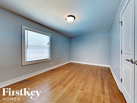 an empty bedroom with wood floors and a window