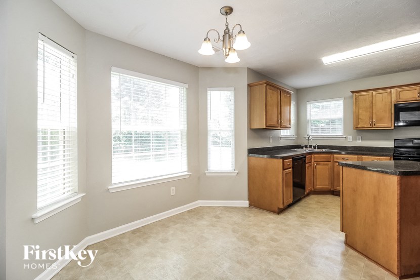 a kitchen with wooden cabinets and a large window
