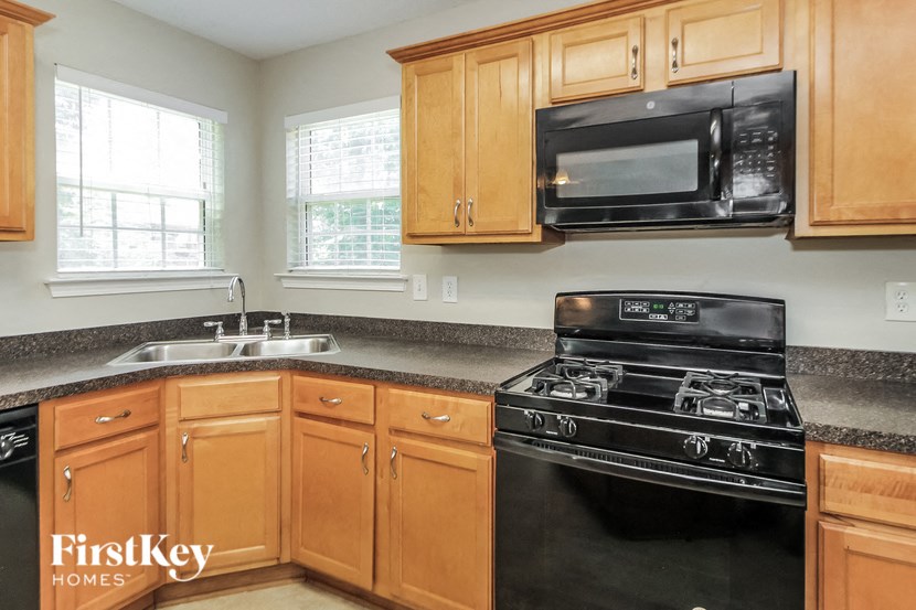 a kitchen with a stove and a sink and a microwave
