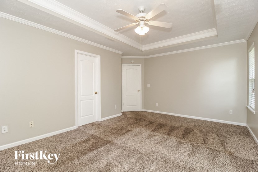 the living room of an empty house with a ceiling fan