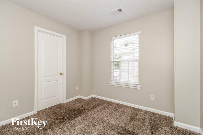 the bedroom of a home with a door and a window