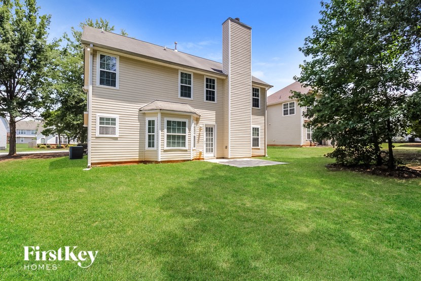 a white house with a yard and a tree