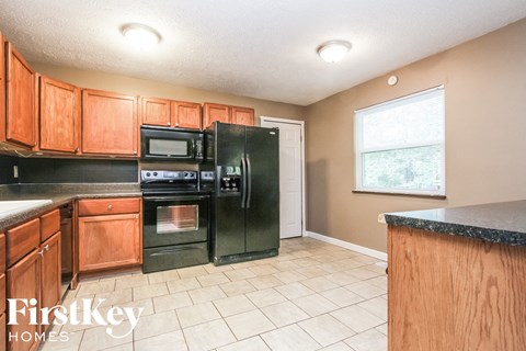 A kitchen with wooden cabinets and black appliances.