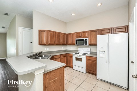 a kitchen with white appliances and wooden cabinets