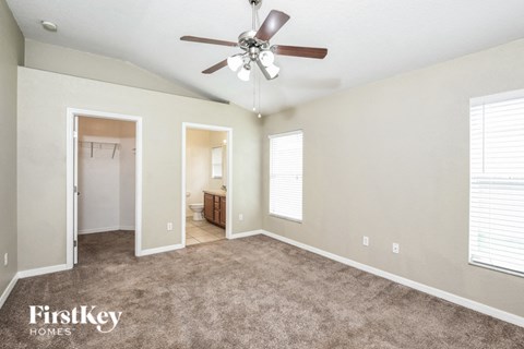 a living room with carpet and a ceiling fan