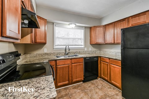 A kitchen with wooden cabinets and black appliances.