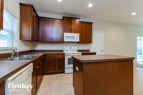 A kitchen with brown cabinets and a white oven.