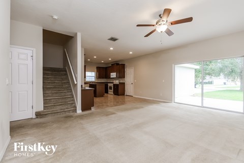 A spacious living room with a staircase leading to the upper floor.