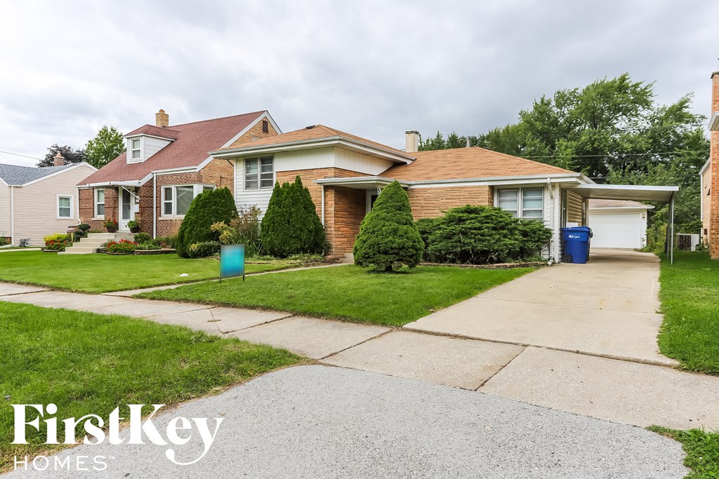 a house with a driveway and lawn in front of it