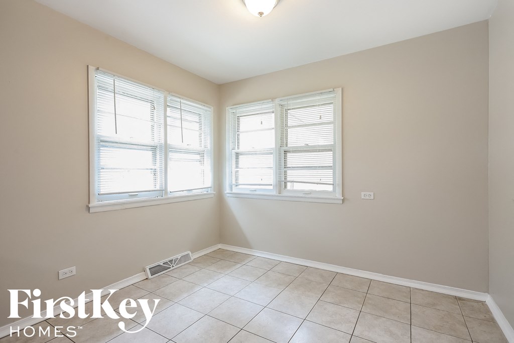 a empty room with two windows and a tiled floor