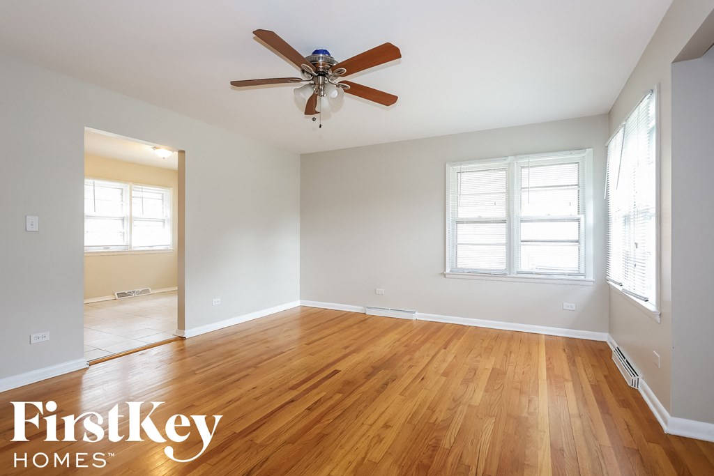 a living room with wood floors and a ceiling fan