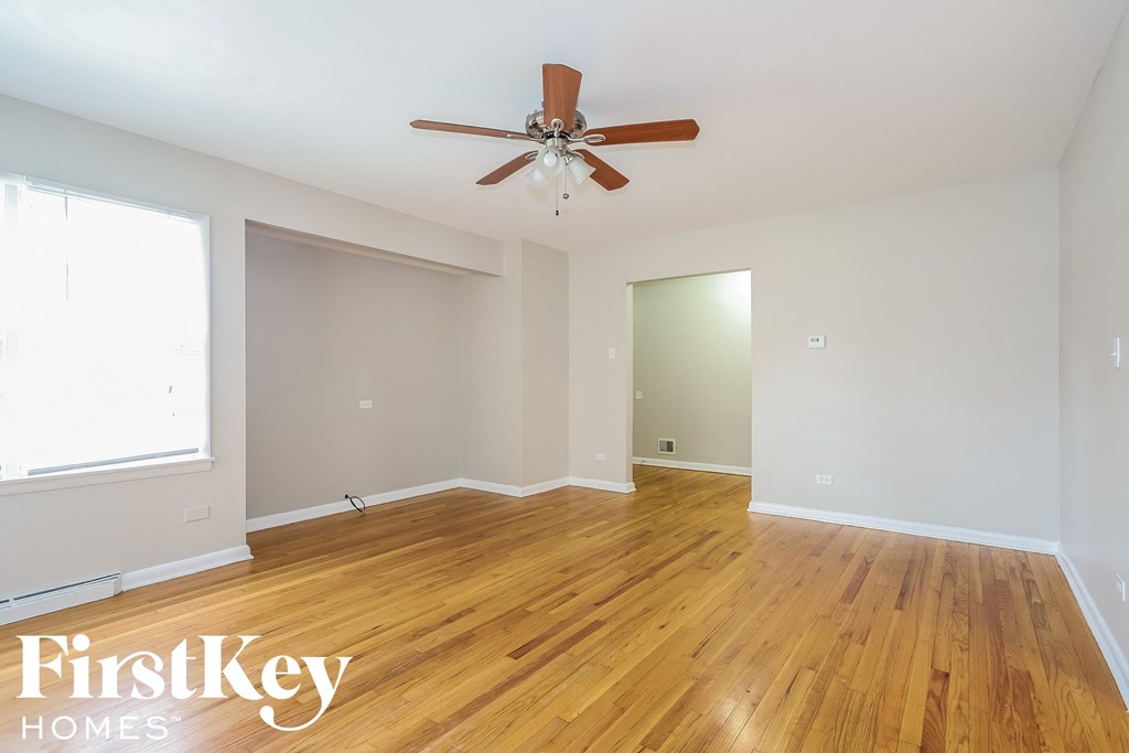 a living room with wood floors and a ceiling fan