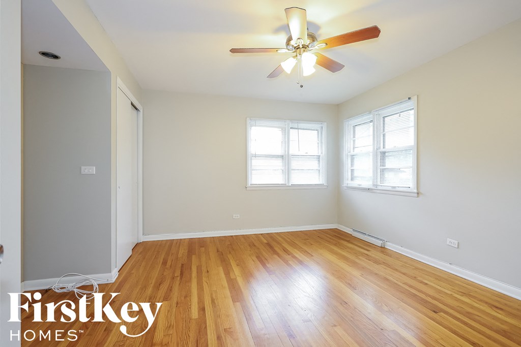 a living room with wood floors and a ceiling fan