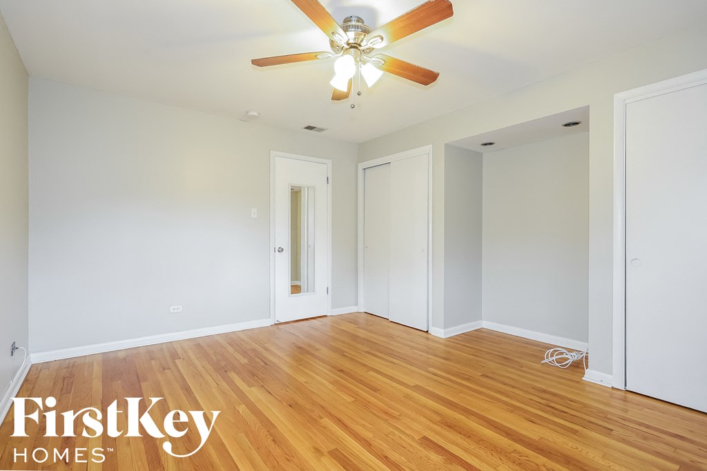 a living room with wood floors and a ceiling fan