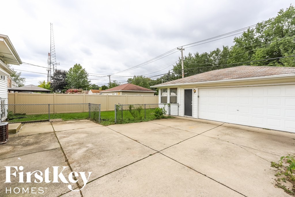 a backyard with a driveway and a white garage door