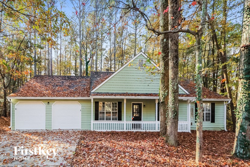 a green and white house in the woods