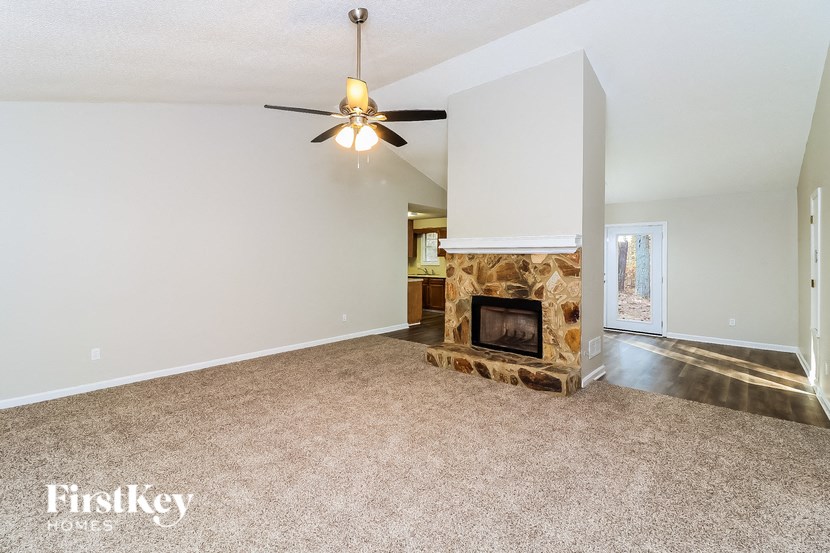 a living room with a fireplace and a ceiling fan