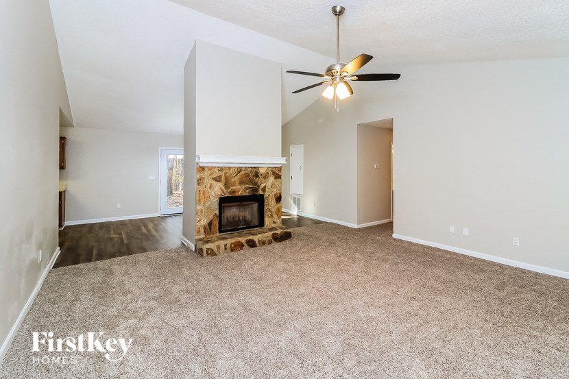 a living room with a fireplace and a ceiling fan