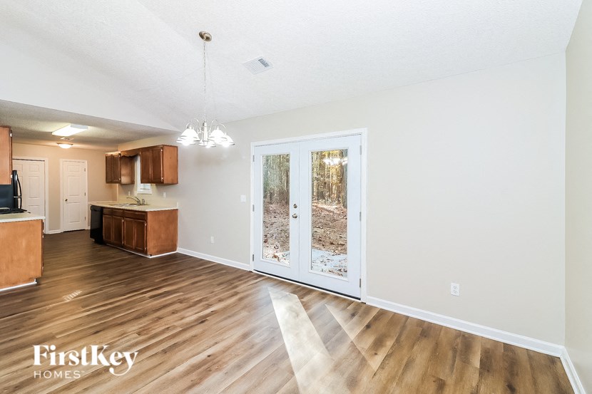 a living room with a door to the yard and a kitchen