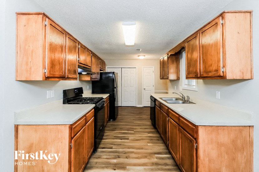a kitchen with wood cabinets and white counter tops and a black stove