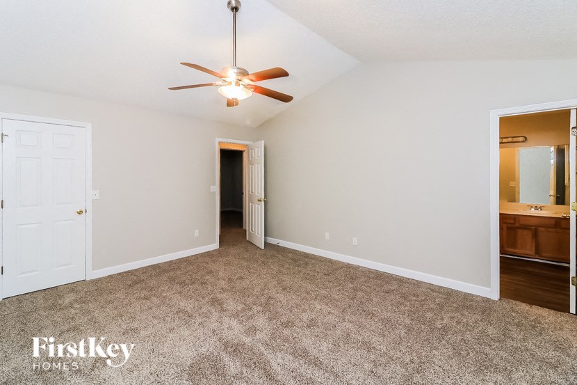 a living room with carpet and a ceiling fan
