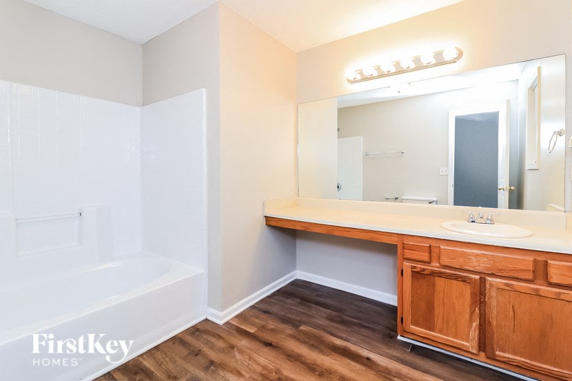 a bathroom with a sink and a tub and a mirror