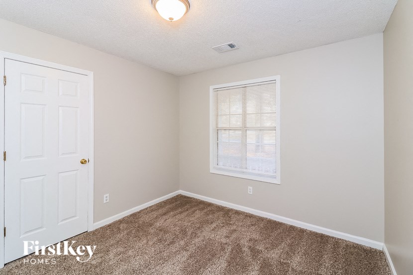 a bedroom with carpet and a white door