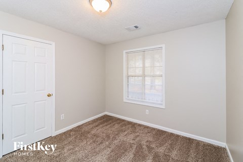 a bedroom with carpet and a white door