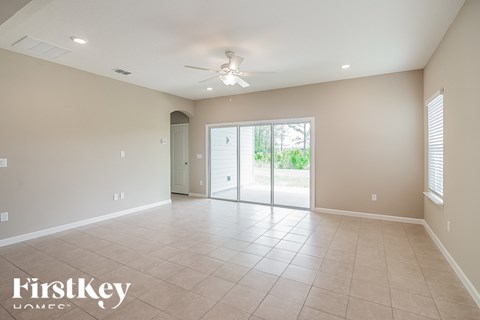 A spacious room with a sliding glass door leading to a balcony.