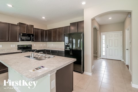 A kitchen with brown cabinets and a granite countertop.