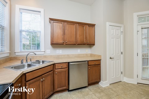 A kitchen with wooden cabinets and a stainless steel dishwasher.