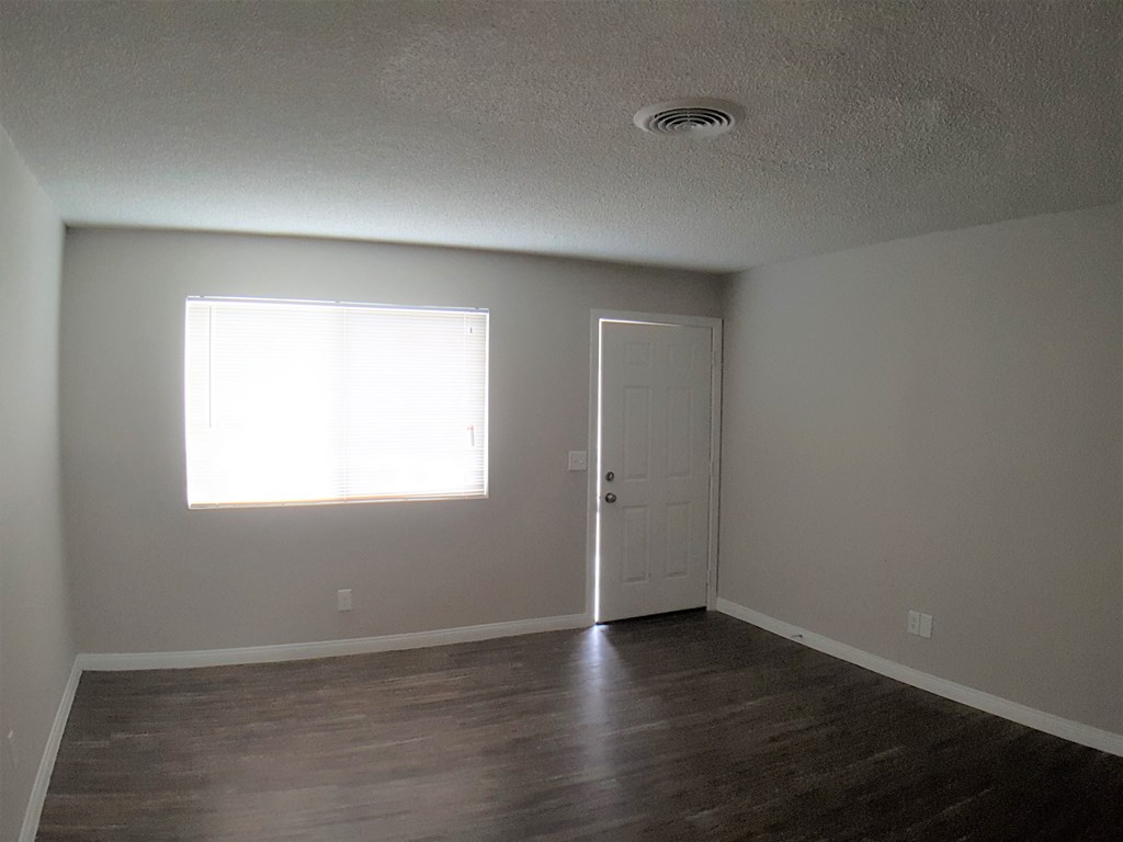 A room with a wooden floor and a white door.