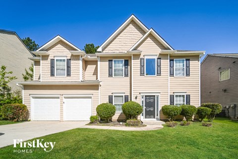 a yellow house with a garage and a lawn