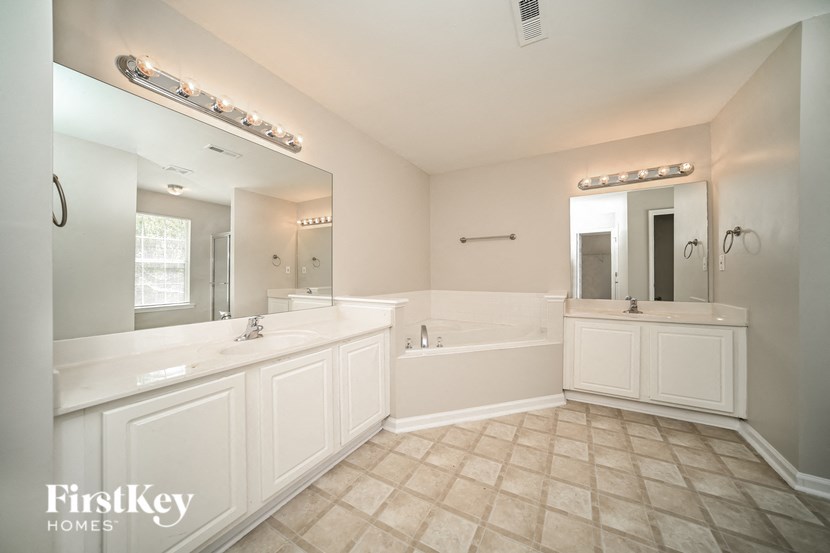 a large white bathroom with two sinks and a tub