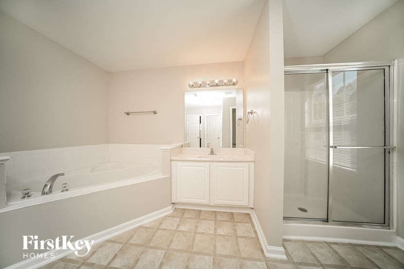 a bathroom with a tub and a sink and a shower