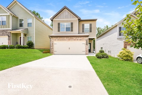 a white driveway in front of a house with a garage door