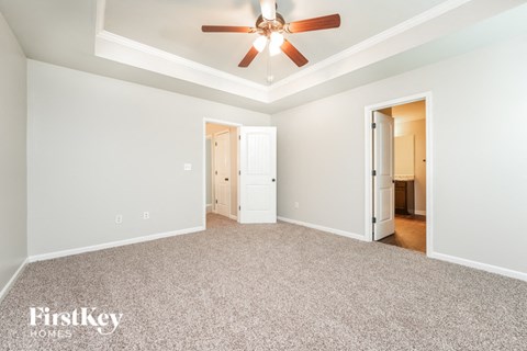 a living room with carpet and a ceiling fan