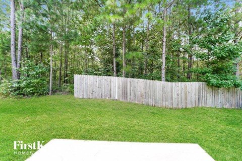 the backyard is fenced in with a privacy fence and trees