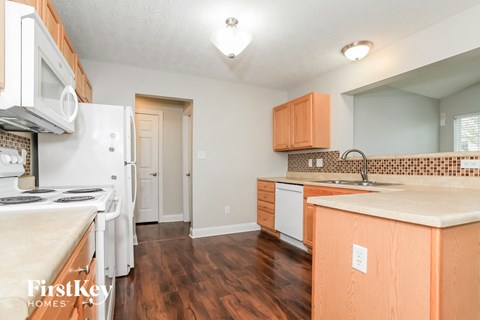 A kitchen with wooden cabinets and a white fridge.