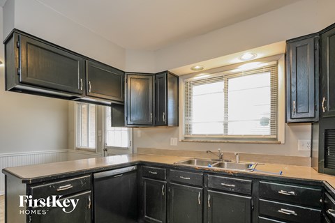 A kitchen with black cabinets and a sink.