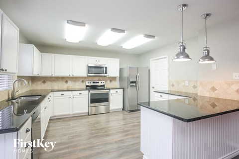 a kitchen with white cabinets and stainless steel appliances