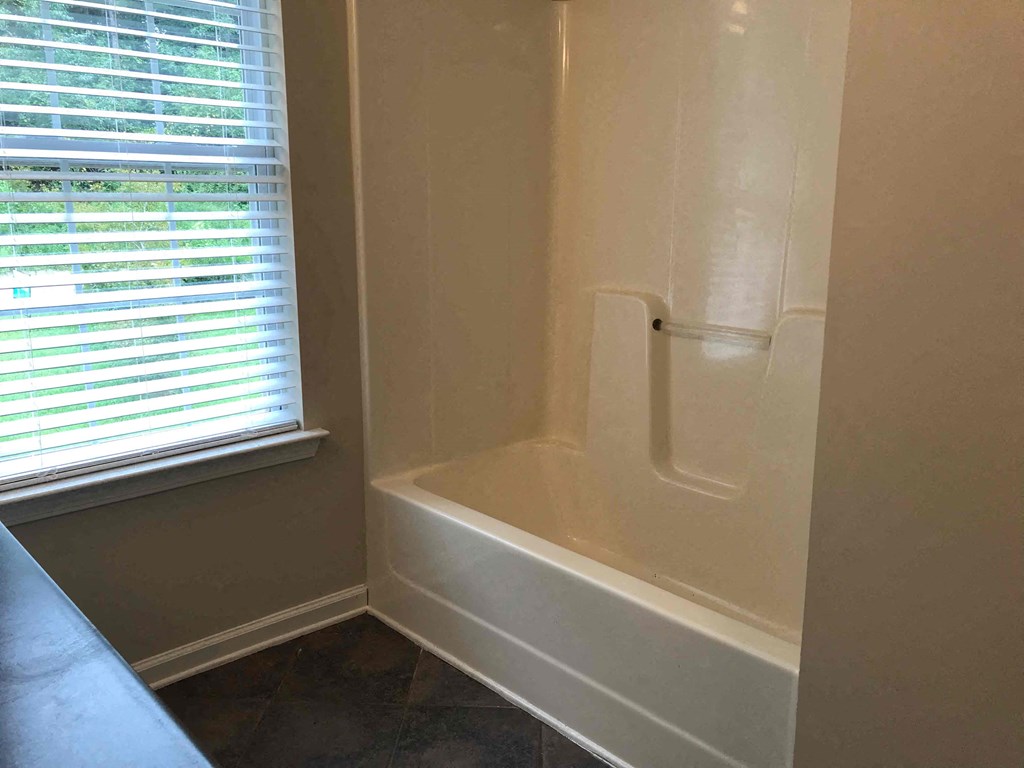 a small bathroom with a shower and a window