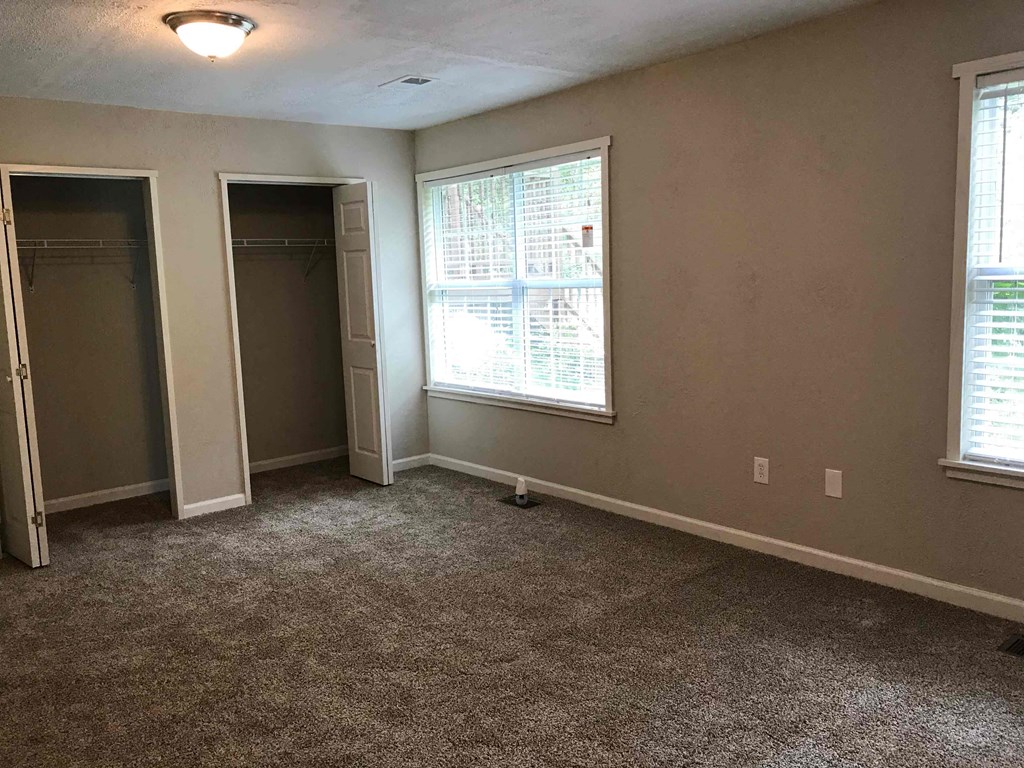 a room with a carpeted floor and two closets