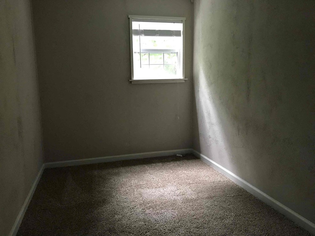 a room with a window and a carpet