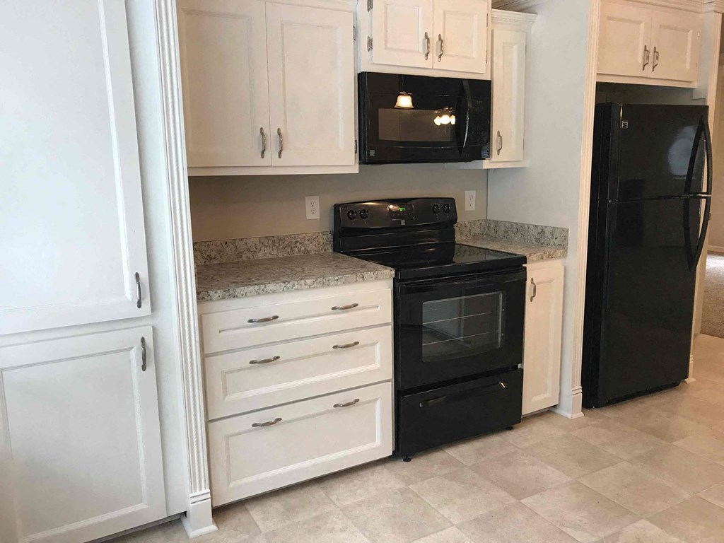 a kitchen with black appliances and white cabinets
