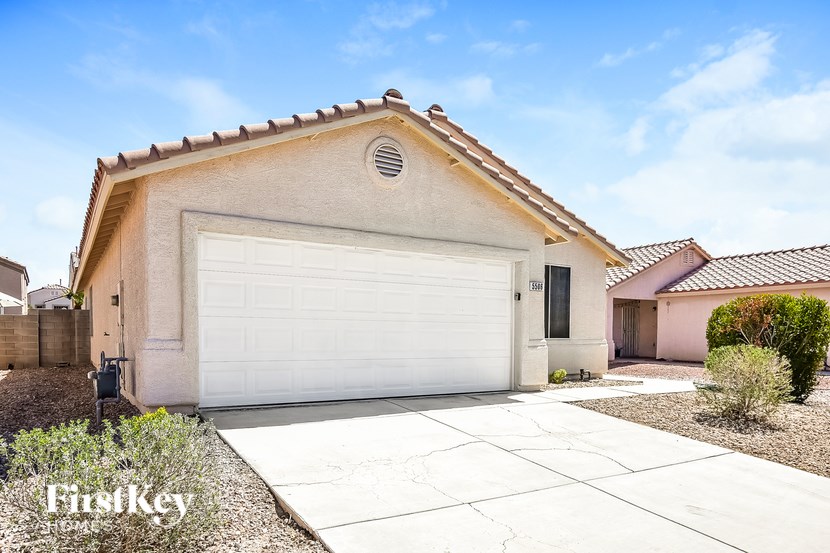 A house with a garage door and a driveway in front.