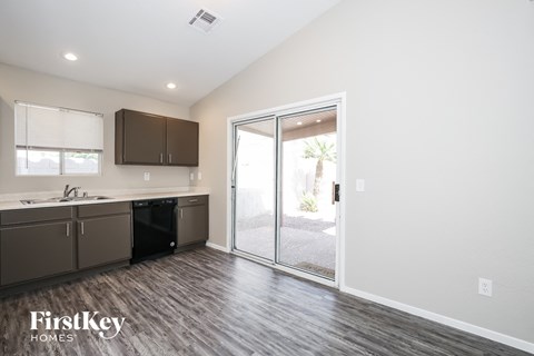 A kitchen with a sink, cabinets, and a window.