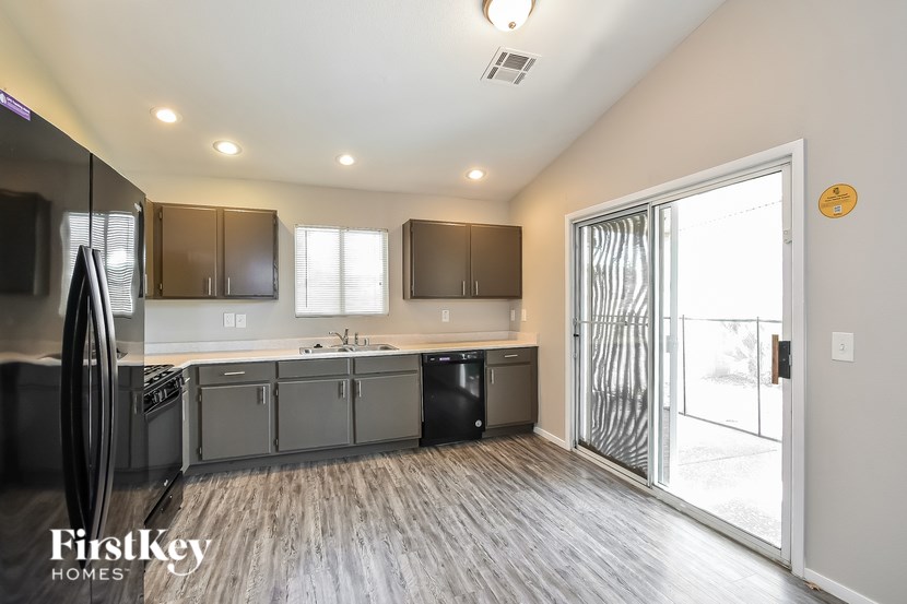 A kitchen with a refrigerator, cabinets, and a dishwasher.